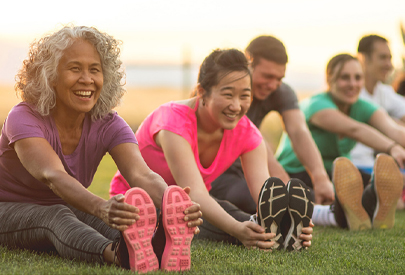 People stretching on a lawn and exercising. (c) UC Davis Regents. All rights reserved.