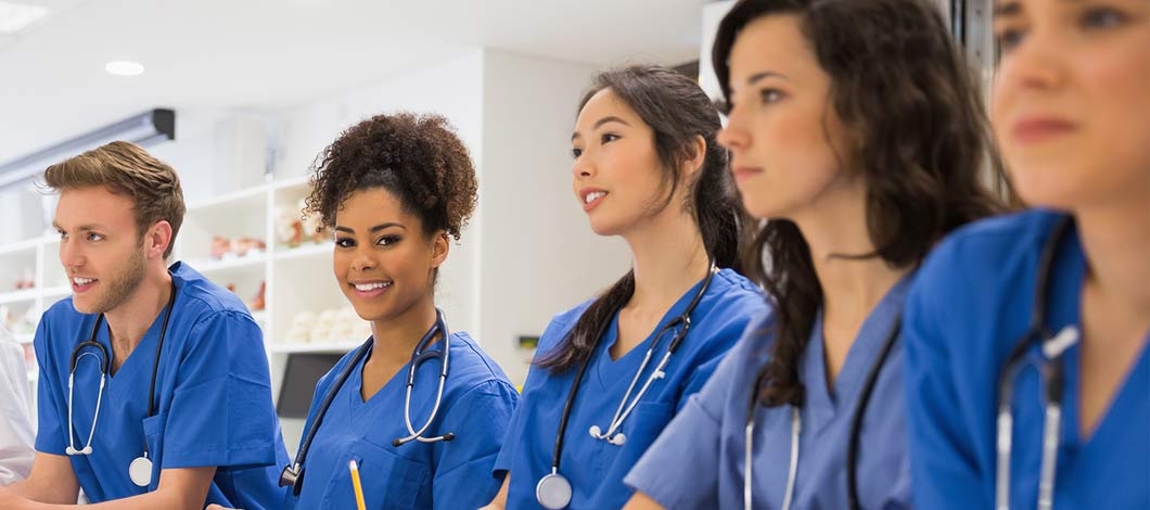 Young nursing staff sitting around table listening to presentation