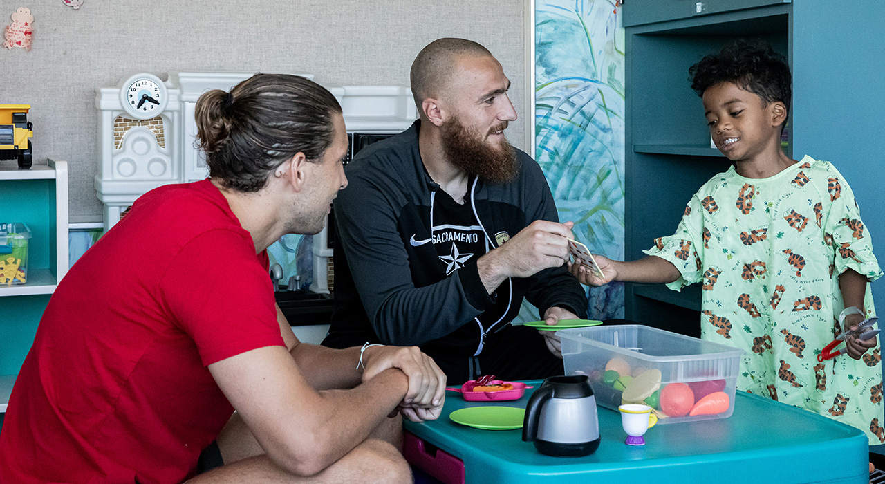 Republic FC players visiting a pediatric patient in the playroom