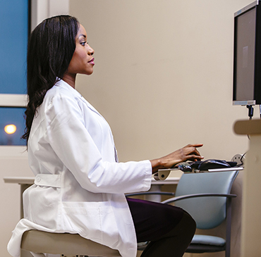 Doctor working at computer station.