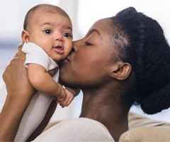 Mother kissing her newborn baby (c) UC Regents. All rights reserved.