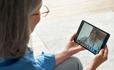 Woman looking a digital tablet (c) UC Davis Regents. All rights reserved.