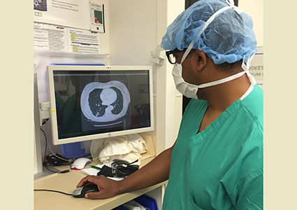 Dr. David Cooke views Mrs. Box’s CT scan of her lungs. Tumor is visible in the lower left quadrant of the scan.