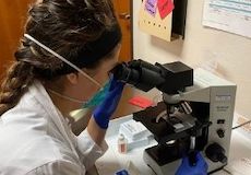 Dermatology student looking through microscope