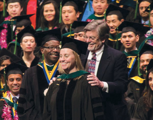 Stephen presenting Emily with her hood at gradiation ceremony