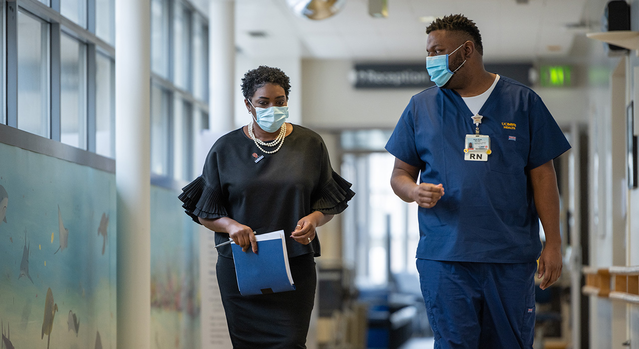 Assistant nurse manager Aron King touches base with UC Davis Health nurse manager Calene Roseman