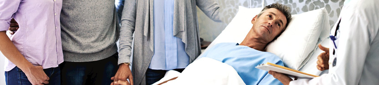 Patient laying in a hospital bed, surrounded by doctor and family. 