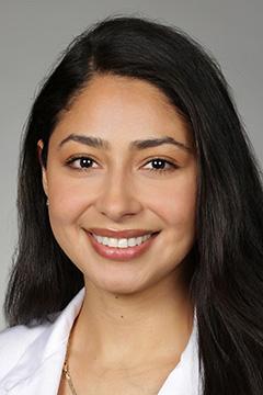 medical student in white coat smiling