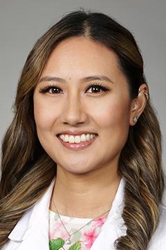 medical student in white coat smiling