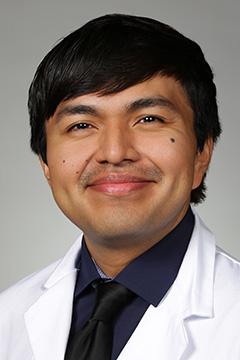 medical student in white coat smiling