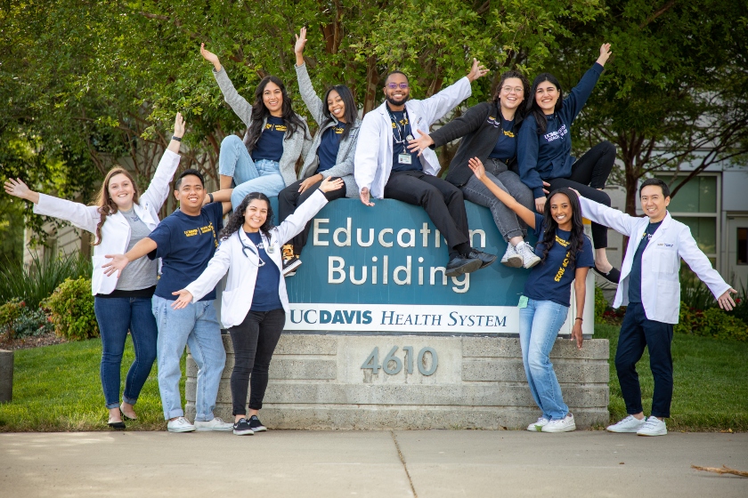 A picture of medical students by the Education Building Sign 