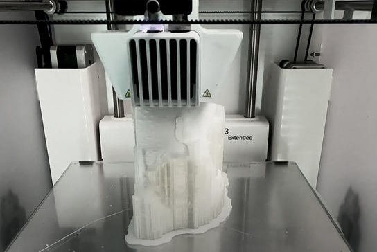A 3D printer operating to create a portion of a model skull.