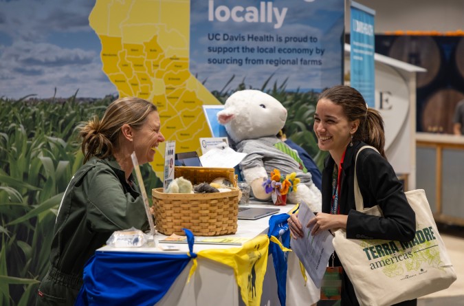 Two women talking at a booth 
