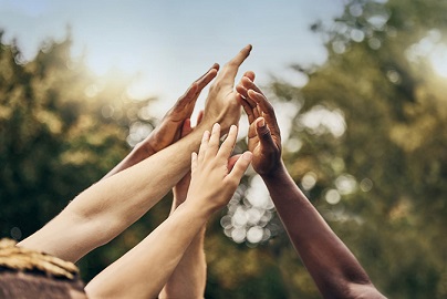 Group of uplifted hands converging into the center together