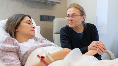 Volunteer Chaplain sitting with a hospitalized woman.