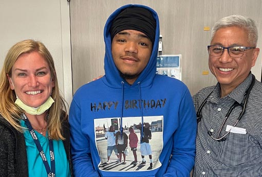 Adolescent male patient with physician and nurse in clinic