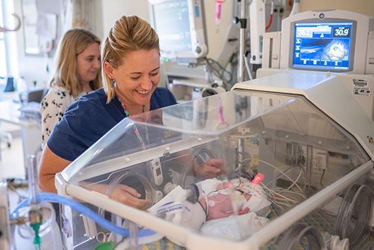 Nurse in NICU monitoring breastmilk analysis equipment