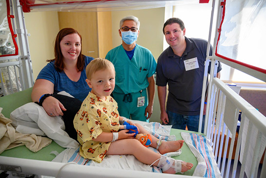 Owen sitting in hospital bed surrounded by health care workers