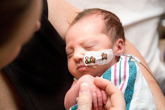 Baby Quinn in mom's arms at NICU