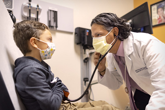 Pediatrician Fernandez y Garcia performing check-up on young male patient