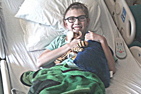 boy smiling while in a hospital bed