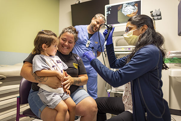 nurses with child and mom preparing for a laryngoscopy procedure