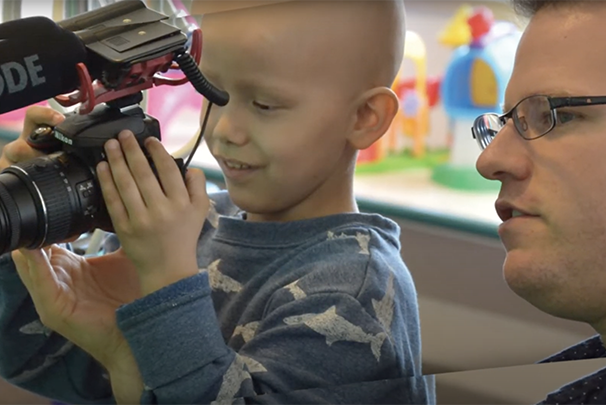 BayKids producer helping child patient film with a camera