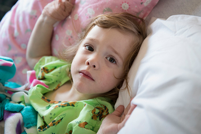 Young girl lying in a hospital bed.