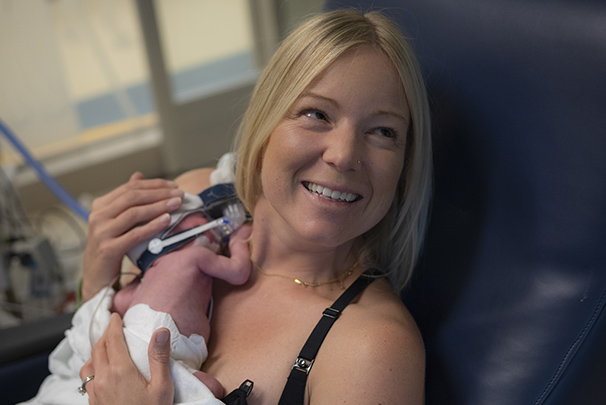 Mother using milk analyzer with her infant child