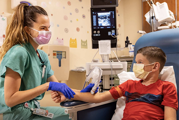 Health care worker using vascular ultrasound on child patient