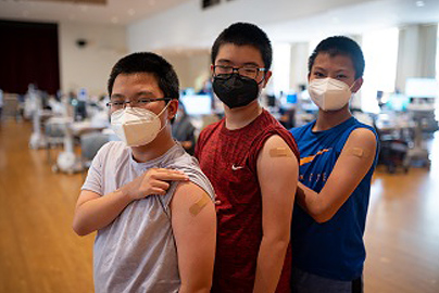 Three teens showing they've been vaccinated