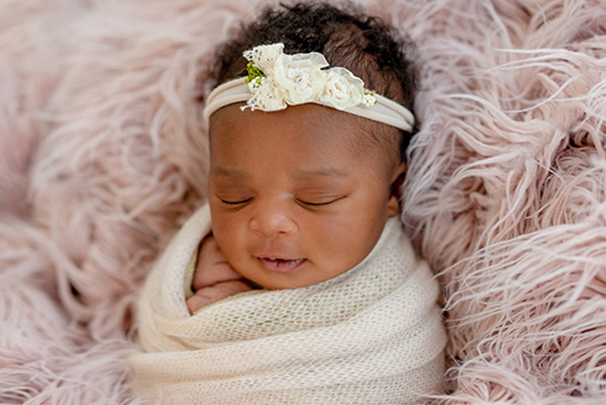 newborn swaddled in pink blanket