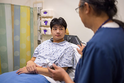 Adolescent male with nurse in exam room