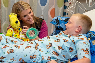 Ginger, a child life support specialist uses medical play to demonstrate a procedure with patient