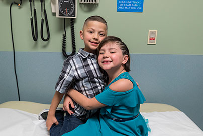 Circle Value, Compassion, two siblings hug each other, big sister and little brother