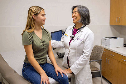 Older female doctor and femail adolscent patient meet in clinic room