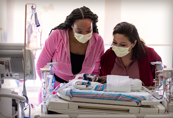 UC Davis neonatologist with parent and infant in NICU room
