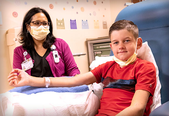 UC Davis child life specialist helping young boy with procedure in medical office