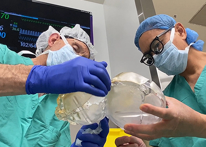 Dr. Wong and Dr. Edwards looking at a 3D printed model.