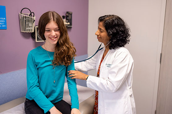 Adolescent female patient being examined by physician in clinic