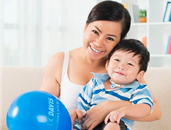 A mother holding a with child who has a tracheostomy.