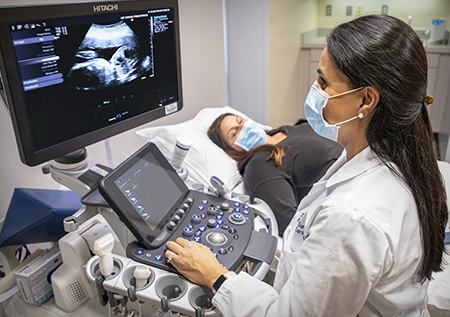 Dr. Sunderli performing echocardiogram on mother