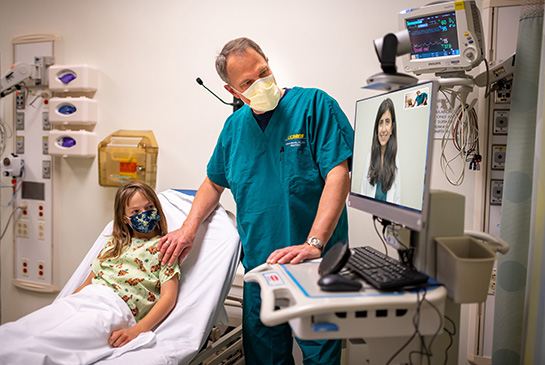 Dr. Marcin and telehealth physician assisting patient