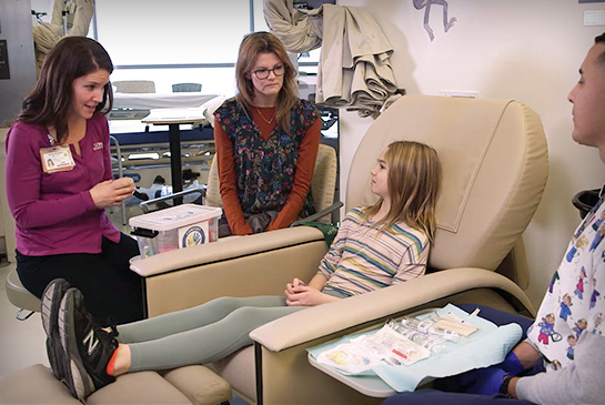 Health care workers supporting child patient in a hospital room