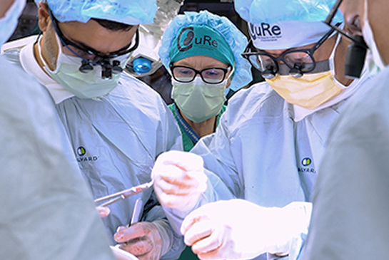 An operating room with surgeons and nurses working on a patient.