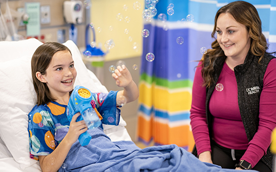 Pediatric patient and nurse playing with bubbles