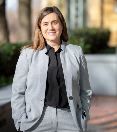 Courtney Lyles smiles outdoors wearing a grey suit.