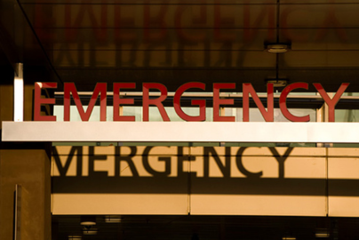 A sign above hospital doors reads "Emergency."