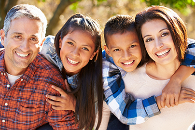 Family of four hugging and smiling.