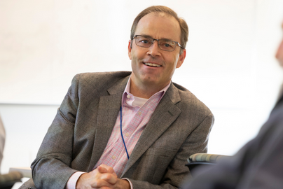 Joshua Fenton smiles while seated.